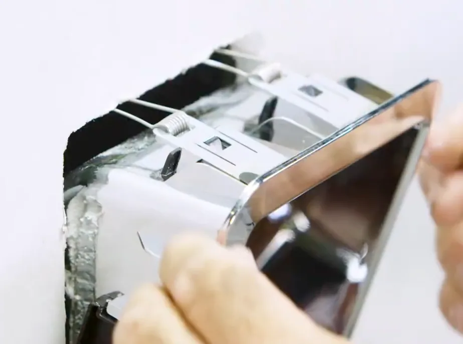 Slide the SmartRoll housing into the wall cavity and snap the magnetic chrome faceplate on